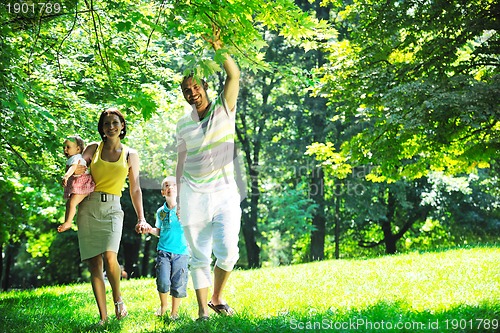 Image of happy young couple with their children have fun at park