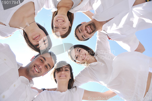 Image of Group of happy young people in circle at beach