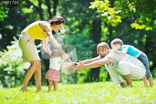 Image of happy young couple with their children have fun at park