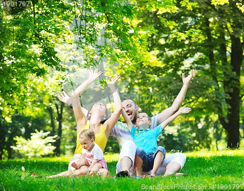 Image of happy young couple with their children have fun at park