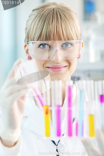 Image of female researcher holding up a test tube in lab