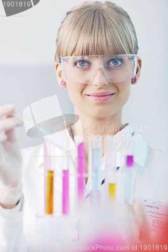 Image of female researcher holding up a test tube in lab