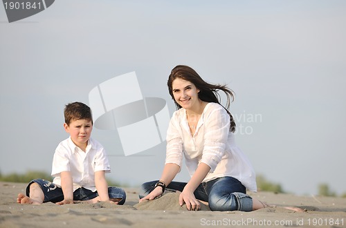 Image of mom and son relaxing on beach