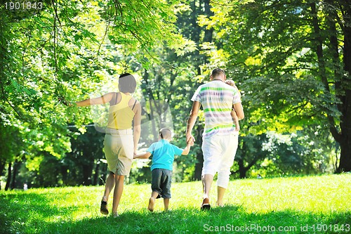 Image of happy young couple with their children have fun at park