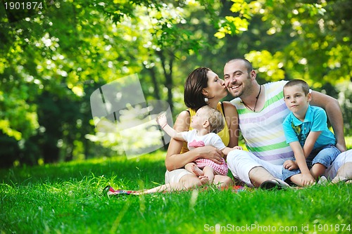 Image of happy young couple with their children have fun at park