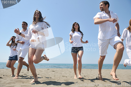 Image of happy people group have fun and running on beach