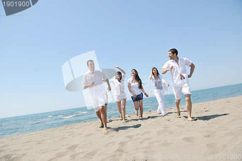 Image of happy people group have fun and running on beach