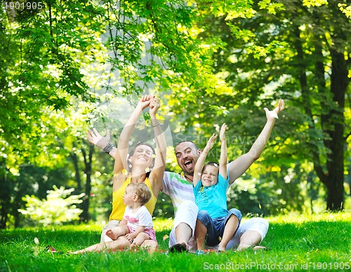 Image of happy young couple with their children have fun at park