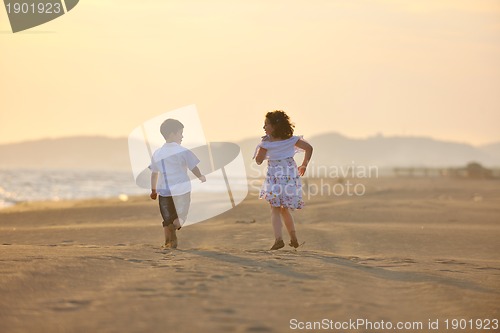 Image of happy young family have fun on beach at sunset