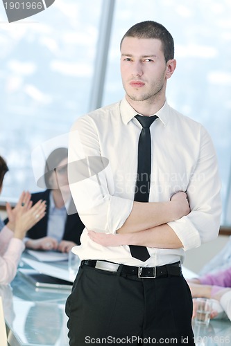 Image of young business man alone in conference room