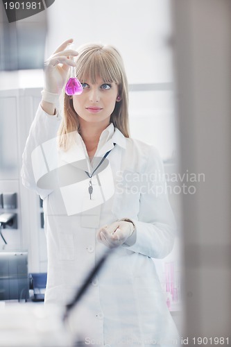 Image of female researcher holding up a test tube in lab