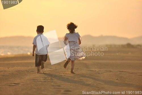 Image of happy young family have fun on beach at sunset