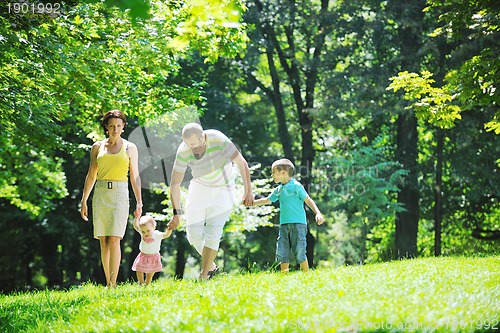 Image of happy young couple with their children have fun at park