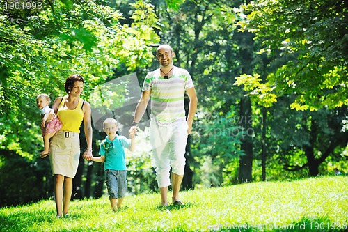 Image of happy young couple with their children have fun at park