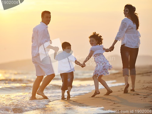 Image of happy young family have fun on beach at sunset