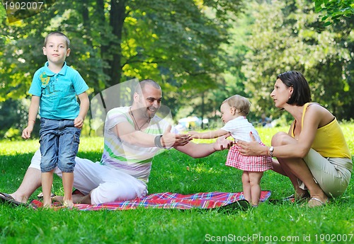 Image of happy young couple with their children have fun at park