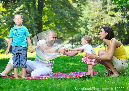 Image of happy young couple with their children have fun at park