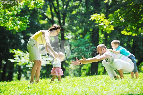 Image of happy young couple with their children have fun at park