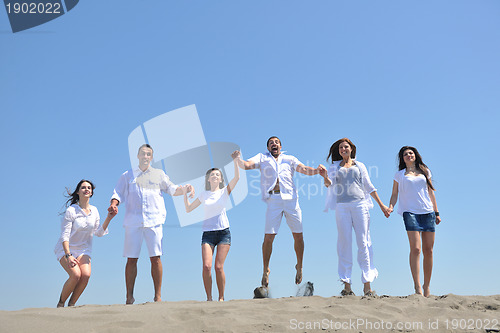 Image of happy people group have fun and running on beach