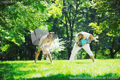 Image of happy young couple with their children have fun at park
