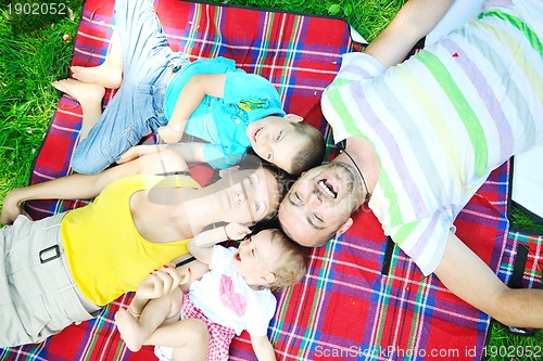 Image of happy young couple with their children have fun at park