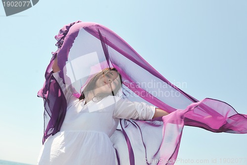 Image of beautiful young woman on beach with scarf