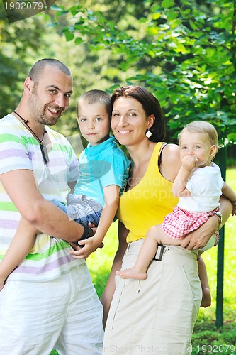Image of happy young couple with their children have fun at park