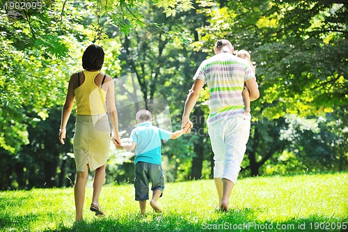 Image of happy young couple with their children have fun at park