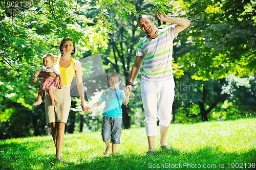 Image of happy young couple with their children have fun at park