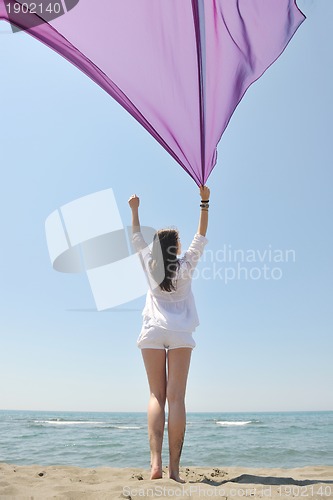 Image of beautiful young woman on beach with scarf