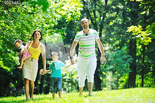 Image of happy young couple with their children have fun at park