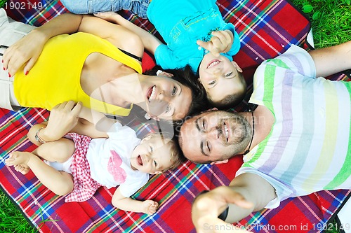 Image of happy young couple with their children have fun at park