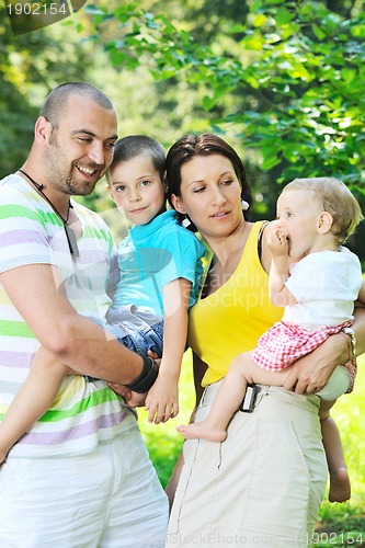 Image of happy young couple with their children have fun at park
