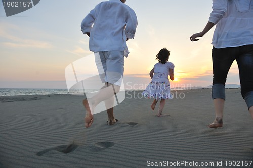 Image of happy young family have fun on beach at sunset