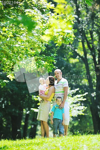 Image of happy young couple with their children have fun at park