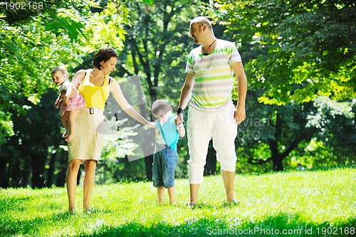 Image of happy young couple with their children have fun at park