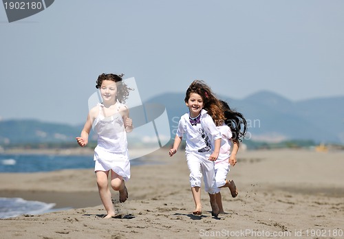 Image of happy child group playing  on beach