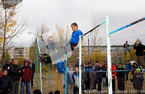 Image of Young guys do exercises on the horizontal bar