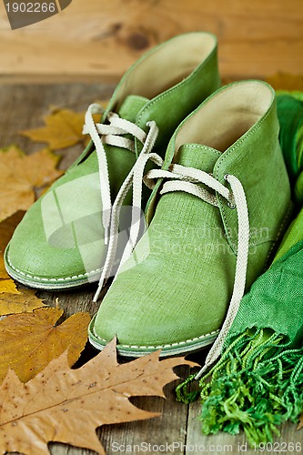 Image of  leather boots, scarf and yellow leaves