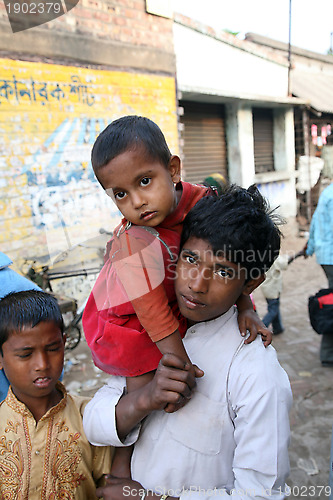 Image of Alindra Jana, holding his little sister Sabita, at remote village Kumrokhali, West Bengal, India