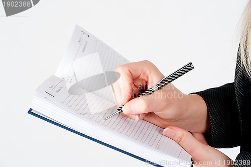 Image of Woman writing in organizer