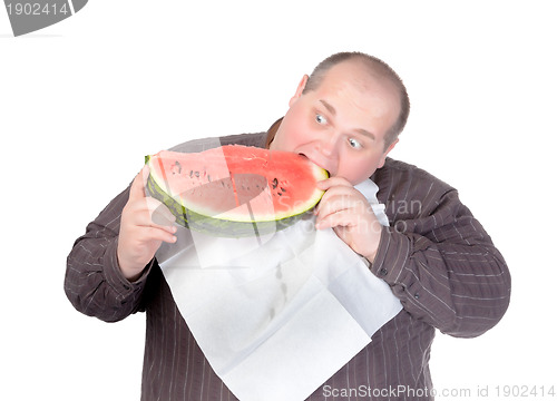 Image of Fat man tucking into watermelon