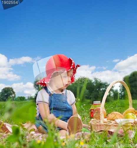 Image of child sitting with picnic basket