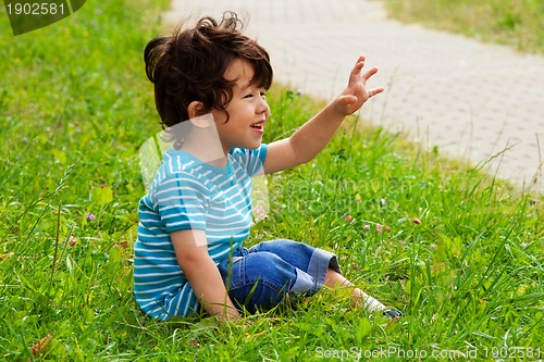 Image of little boy sitting and waving