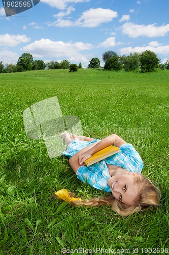 Image of smiling girl laying on lawn