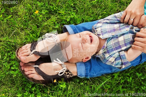 Image of laughing kid laying on mommy's legs