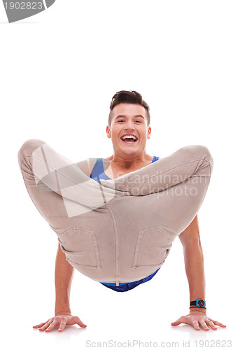 Image of smiling young man standing on his hands