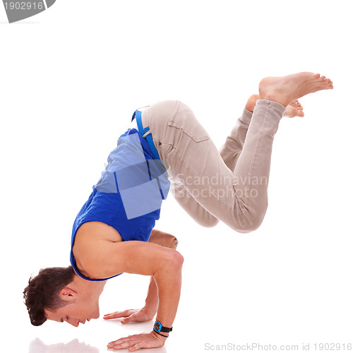 Image of barefoot casual man doing a handstand 