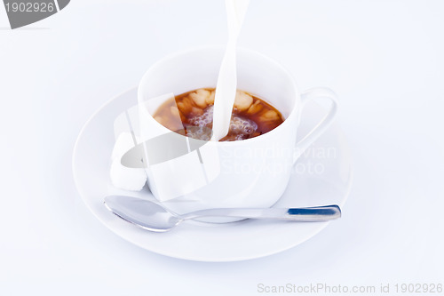 Image of Pouring cream into a cup of coffee 