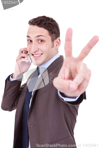 Image of business man making victory sign on phone